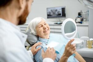woman looks in the mirror after dental implant placement