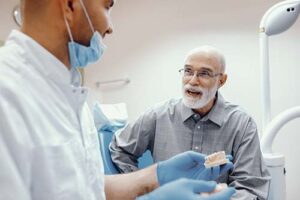man talks with his dentist about flippers and removable partial dentures