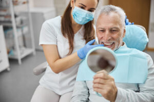 man in dentist chair with a dentist looks at dental implant placement importance