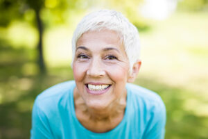 a older adult woman smiles enthusiastically while asking what is a smile makeover