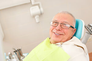 man smiles as he enjoys the benefits of hybrid prosthesis implants