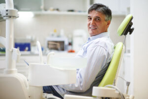 man in dentist's chair learning about the benefits of tooth extractions