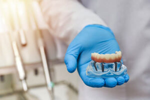 dentist explaining dental bridges to patient using a model