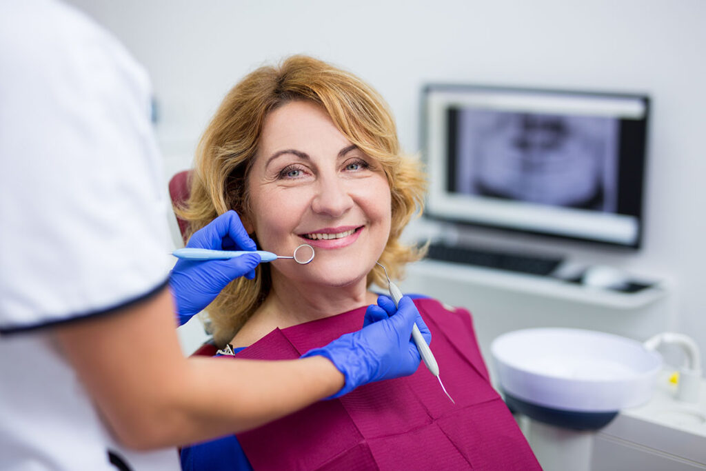 person smiling after going through the tooth replacement process