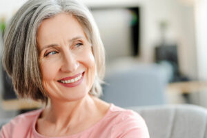 person smiling after seeking teeth replacement options for cancer patients