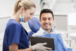 client smiling while technician walks them through harnett dental services