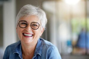 a woman smiles after getting her broken tooth fixed
